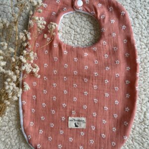 bavoir couleur pêche avec fleurs blanches brodees